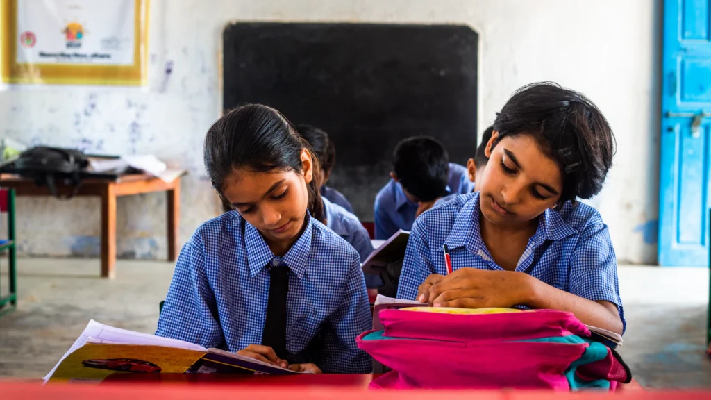 Two girls studying together at a classroom desk